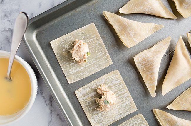 crab ragoons on a cookie sheet