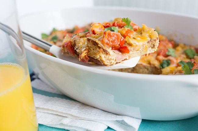 Image of baked southwest breakfast casserole on table beside orange juice