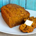 Pumpkin banana bread on a white plate with blue background