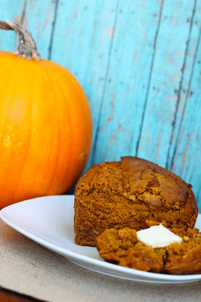 Pumpkin banana bread on a white plate with blue background