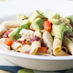 Square image of chicken pasta with avocado bacon and tomatoes