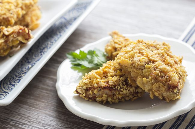 Pieces of baked chicken with crunchy coating on a white plate