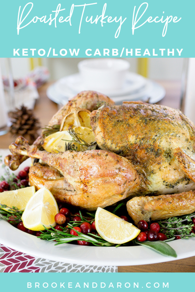 Roasted turkey displayed on a white platter with cranberries lemon and herbs