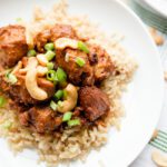 Overhead picture of a white bowl with brown rice and cashew chicken recipe