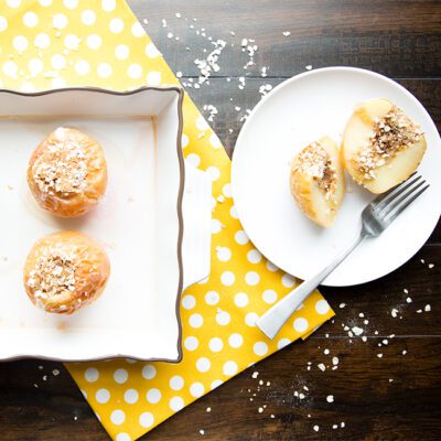 Baked apples on white plate on black counter