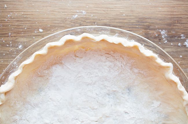 A homemade pie crust in a pie plate for a healthy pumpkin pie