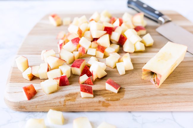 Cutting board with diced apples for apple coleslaw recipe