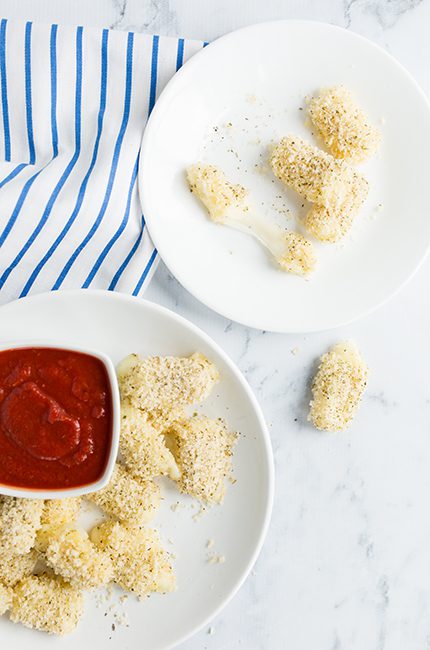 Overhead picture of two plates filled with healthy baked mozzarella bites with marinara sauce
