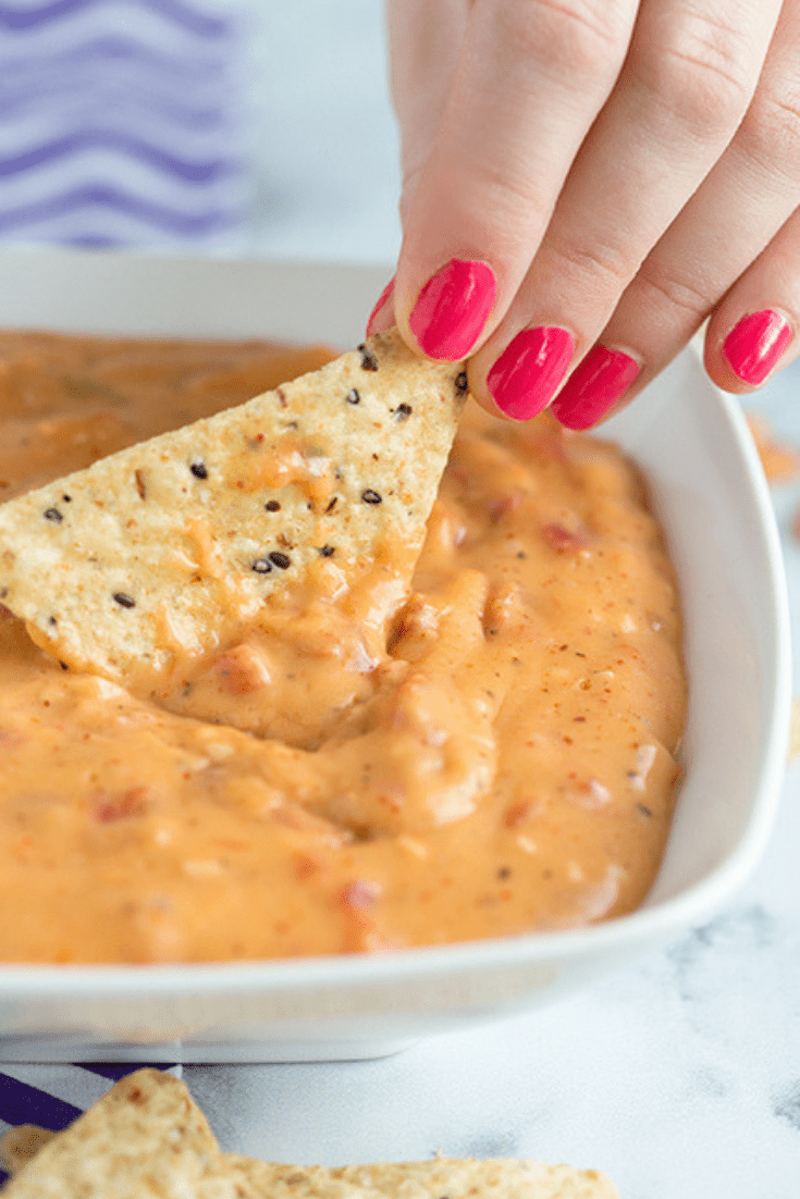 Overhead picture of a bowl filled with queso dip recipe with chips beside it