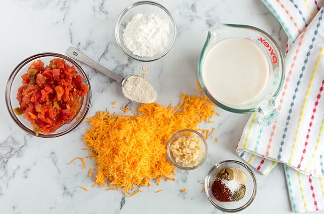 Ingredients for queso dip recipe sitting on a marble counter