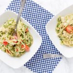 2 bowls of avocado pasta zoodles on white table