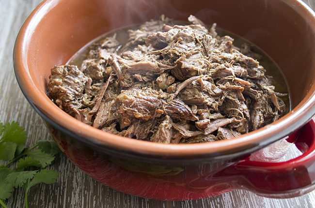 A steaming bowl of beef barbacoa made as a copycat chipotle recipe