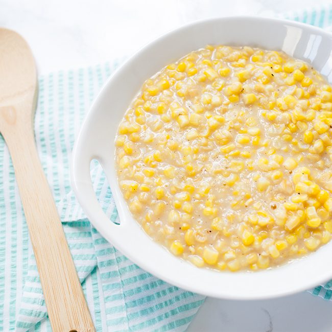 Up close picture of large white bowl filled with cream style corn