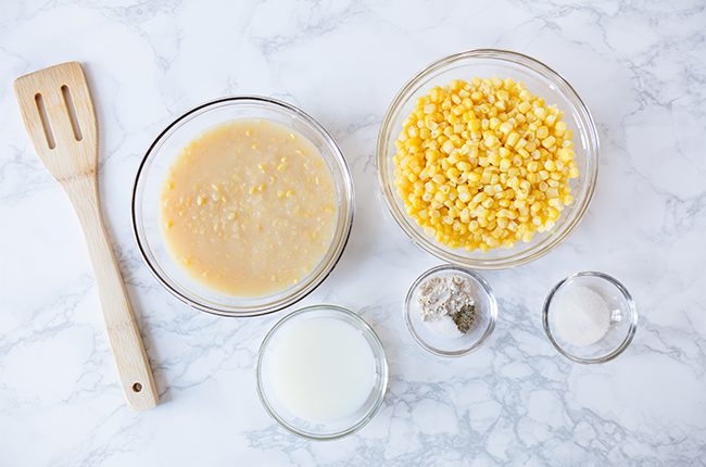 Ingredients for homemade cream corn sitting on marble counter