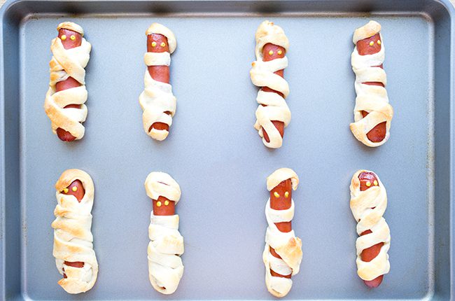 Mummy hot dogs on baking sheet