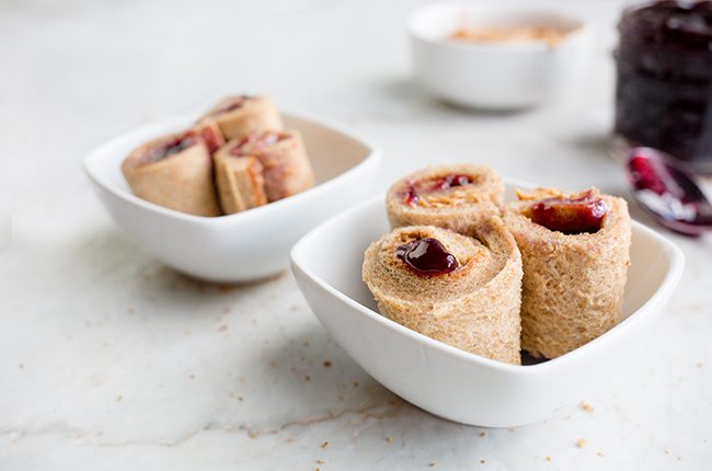 peanut butter and jelly sushi rolls in white bowls on white table
