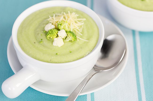 A large white soup bowl filled with broccoli and cauliflower soup