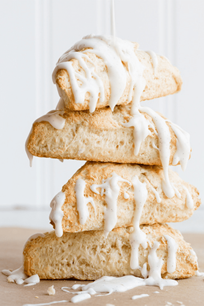 A stack of glazed vanilla bean easy scones recipe prepared on a wooden surface