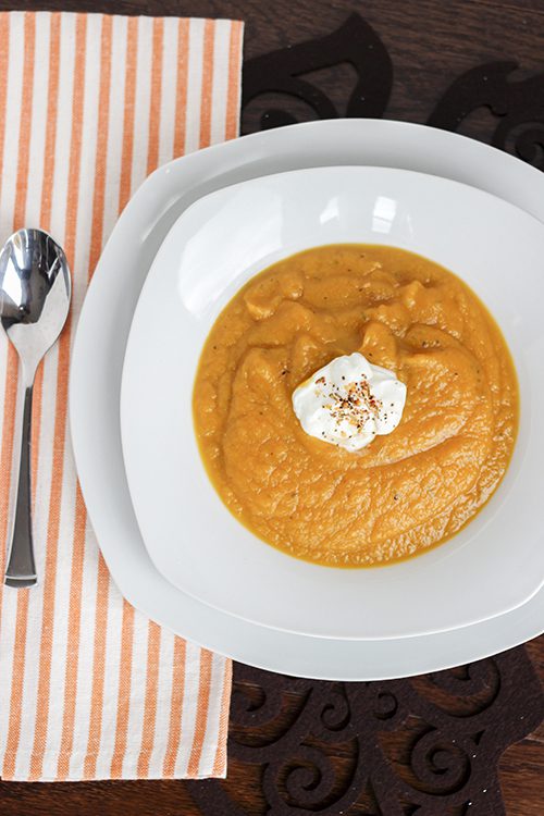 Butternut Squash Soup place setting in white bowl topped withs our cream