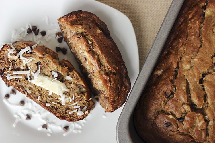 Chocolate chip Coconut Banana Bread sliced with butter on top on a plate