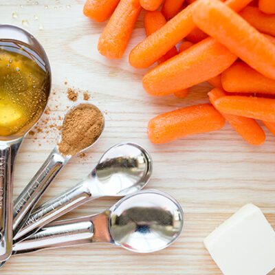 Ingredients for candied carrots sitting on a cutting board