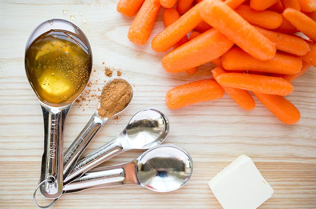 Ingredients for candied carrots sitting on a cutting board