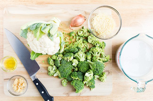 Overhead picture of ingredients for broccoli and cauliflower soup sitting on table