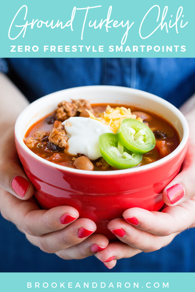 Red bowl being held by woman's hands that is filled with ground turkey chili