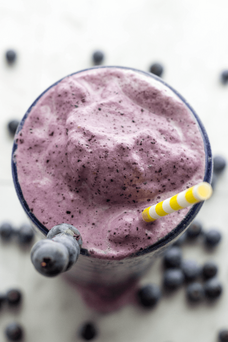 Up close overhead picture of a glass of blueberry protein smoothie