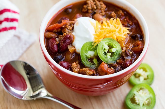 Up close overhead picture of a red bowl filled with turkey chili