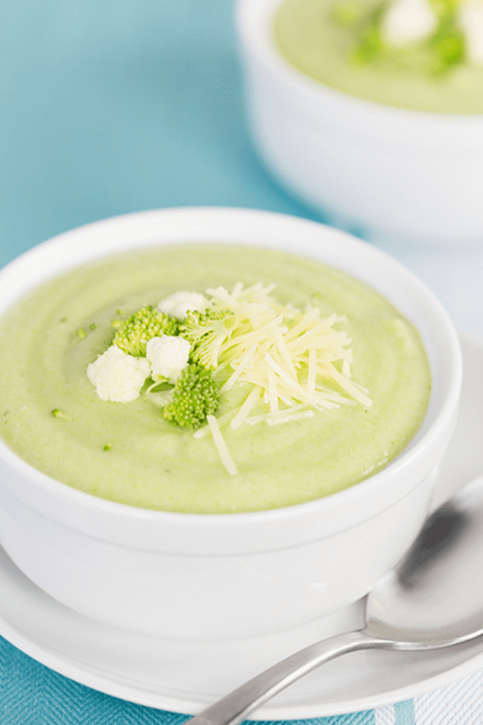 Up close picture of a white bowl filled with broccoli and cauliflower soup