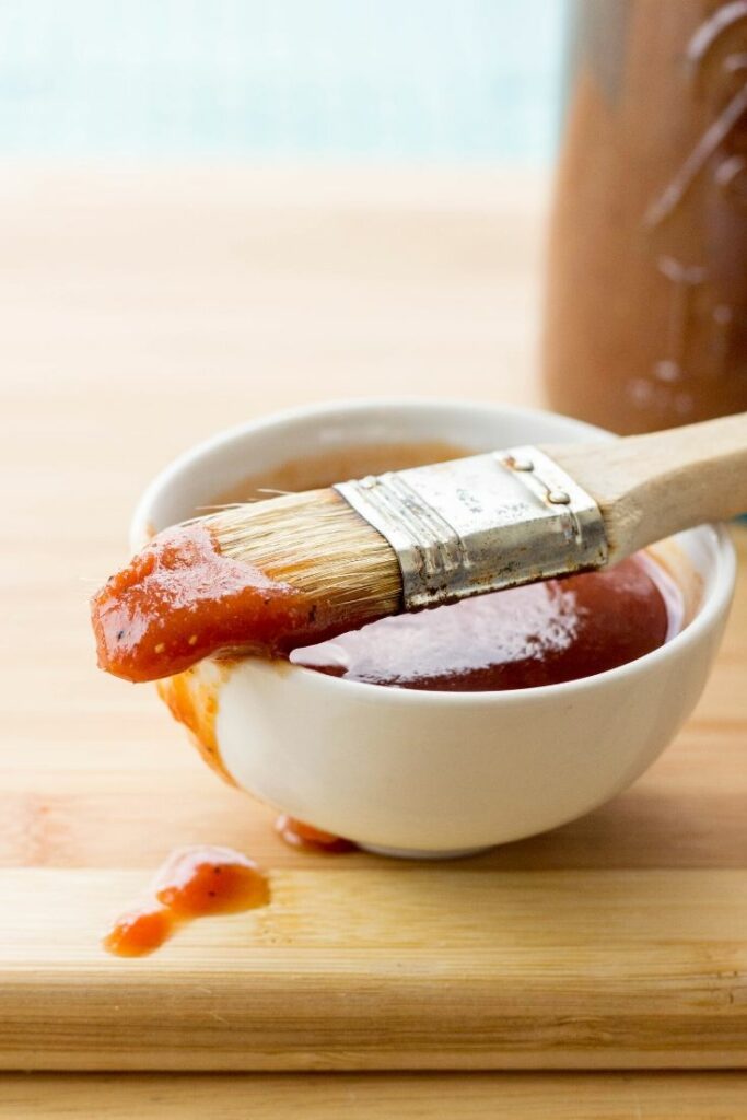 Up close picture of homemade bbq sauce in a bowl on a cutting board