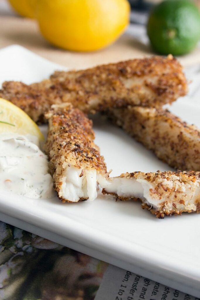 Fish stick recipe on a white plate with one fish stick sliced in half