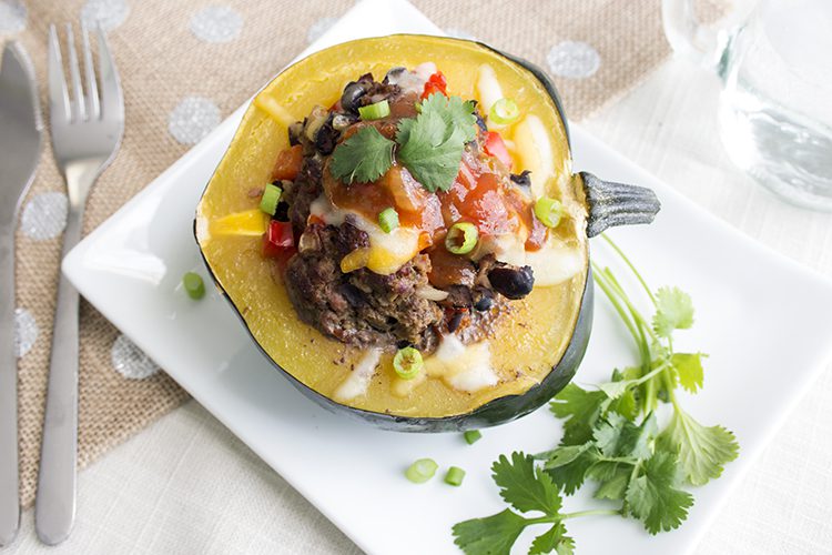 Overhead picture of stuffed acorn squash with ground beef and salsa