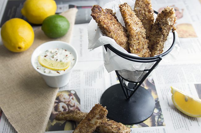 Fish sticks in a wire basket with tartar sauce on the side