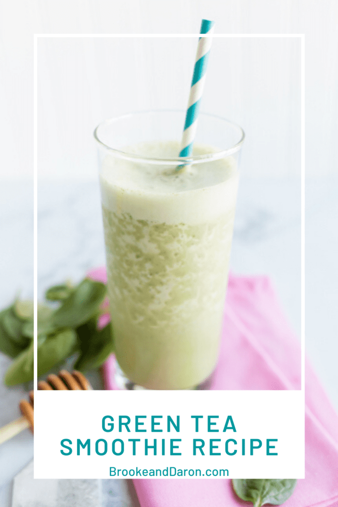 Green tea smoothie in tall clear glass with blue striped straw