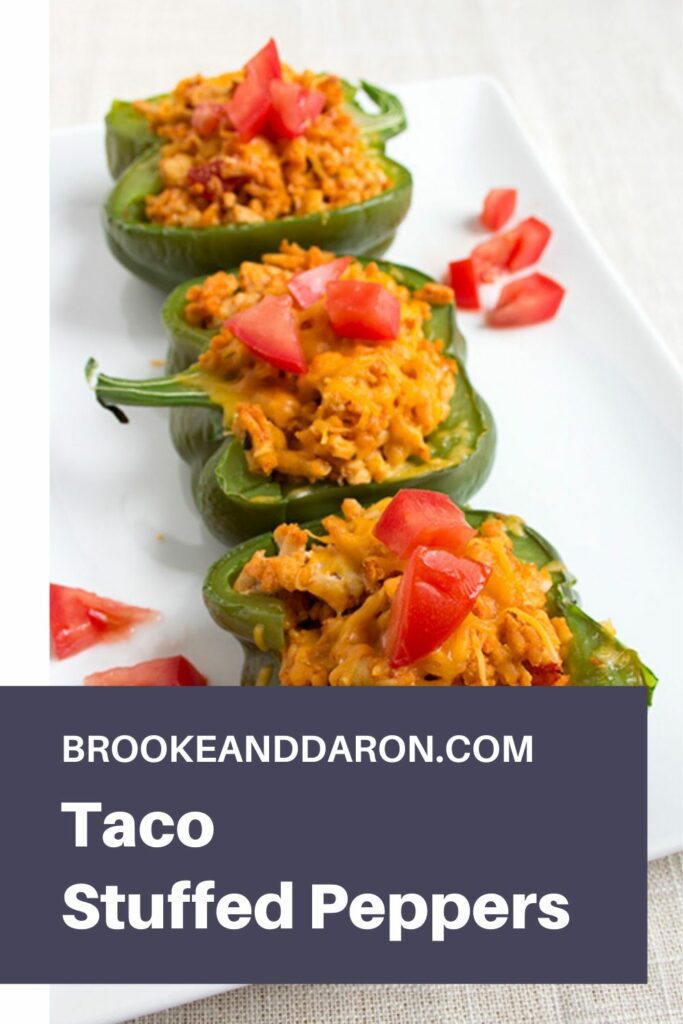 Three bell peppers stuffed with chicken on white plate