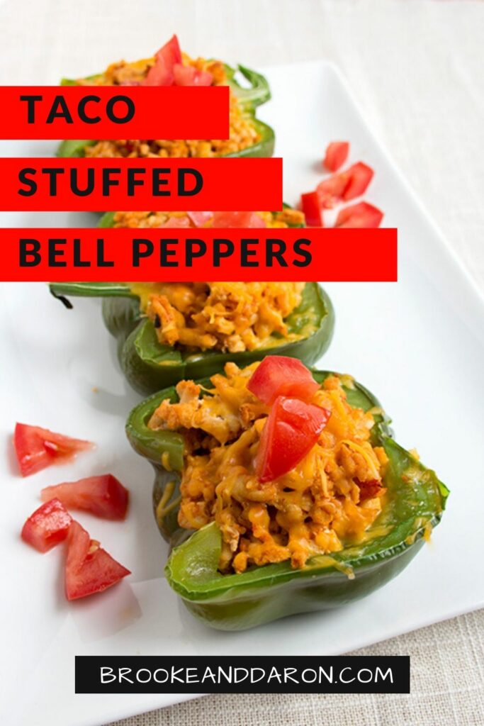 Three bell peppers stuffed with chicken on white plate
