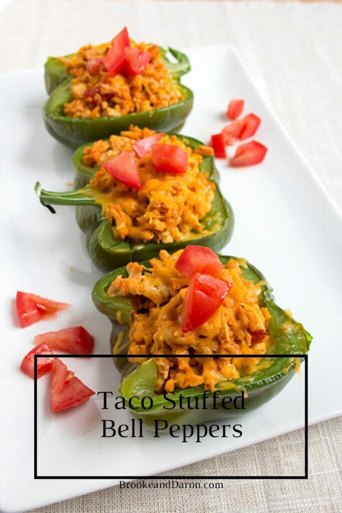 Three bell peppers stuffed with chicken on white plate