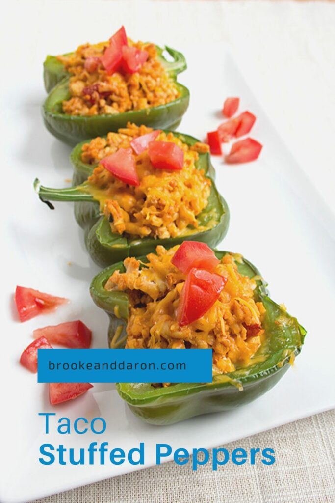 Three bell peppers stuffed with chicken on white plate