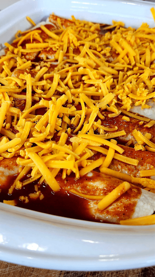 Enchiladas Topped with sauce and cheese before baking