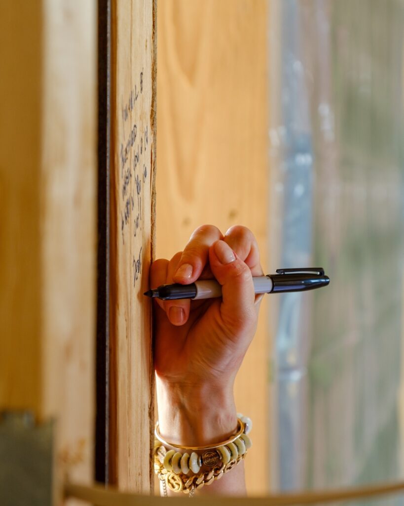 Hand writing Bible Verses on Framing of New Home